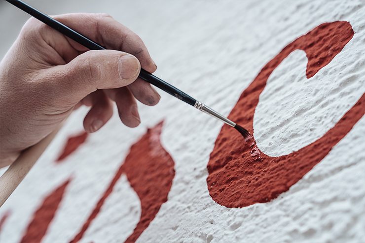 Handgemalter roter Schriftzug an einer Wand